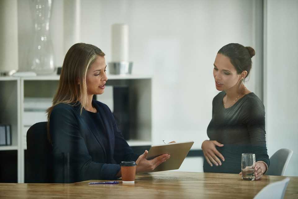 Pregnant woman talking to human resources officer